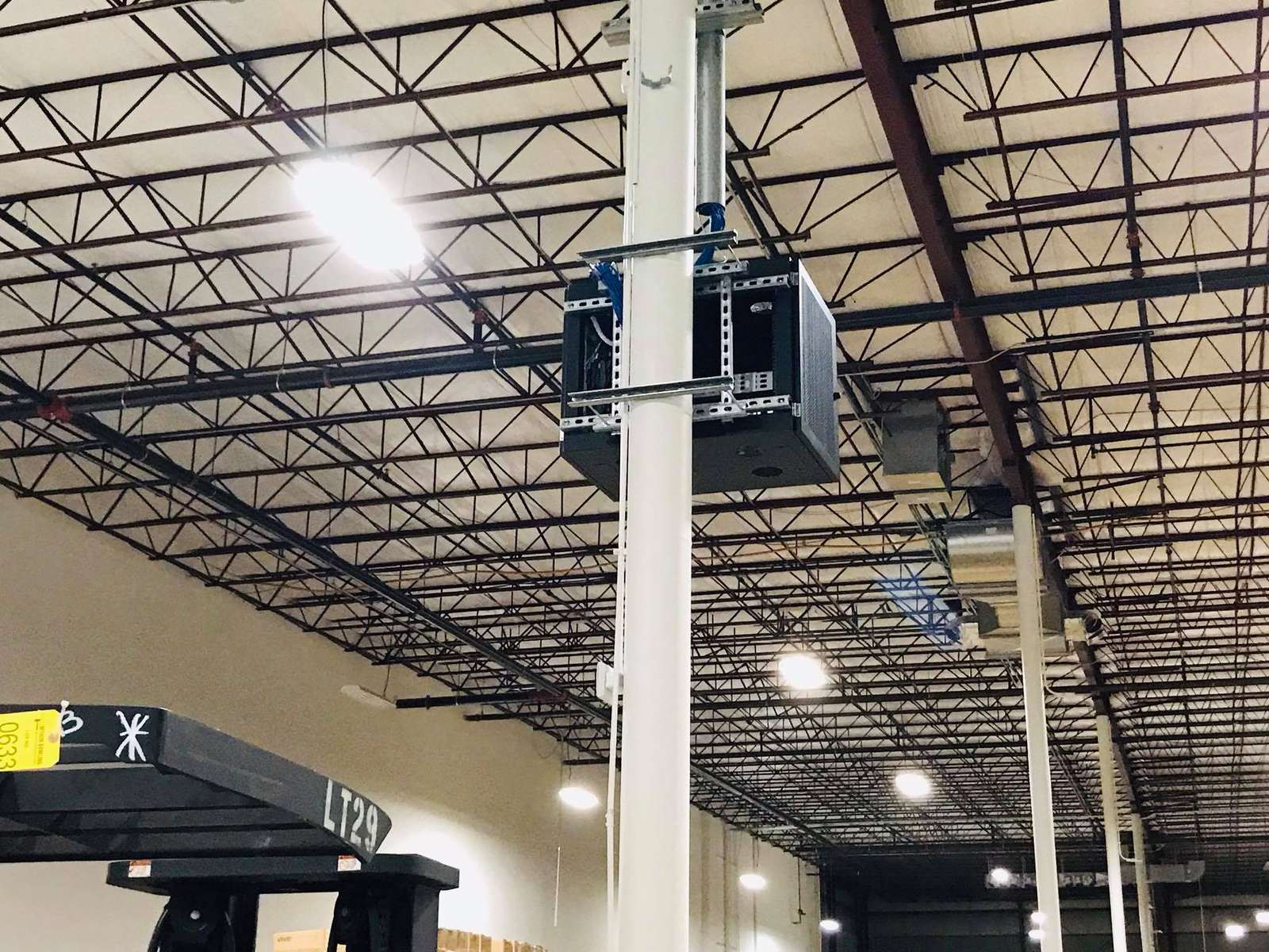 Ceiling-mounted speaker and conduit in a distribution warehouse